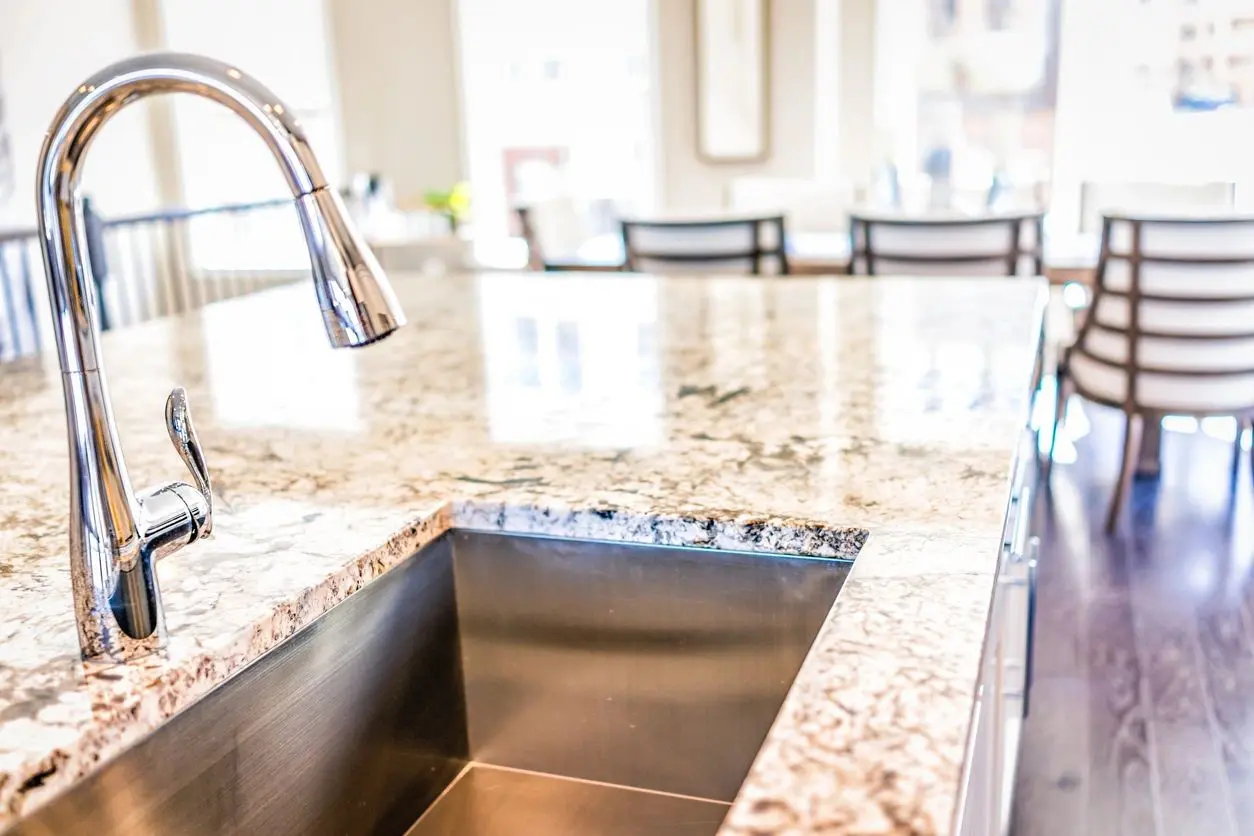 A kitchen with granite counter tops and stainless steel sink.