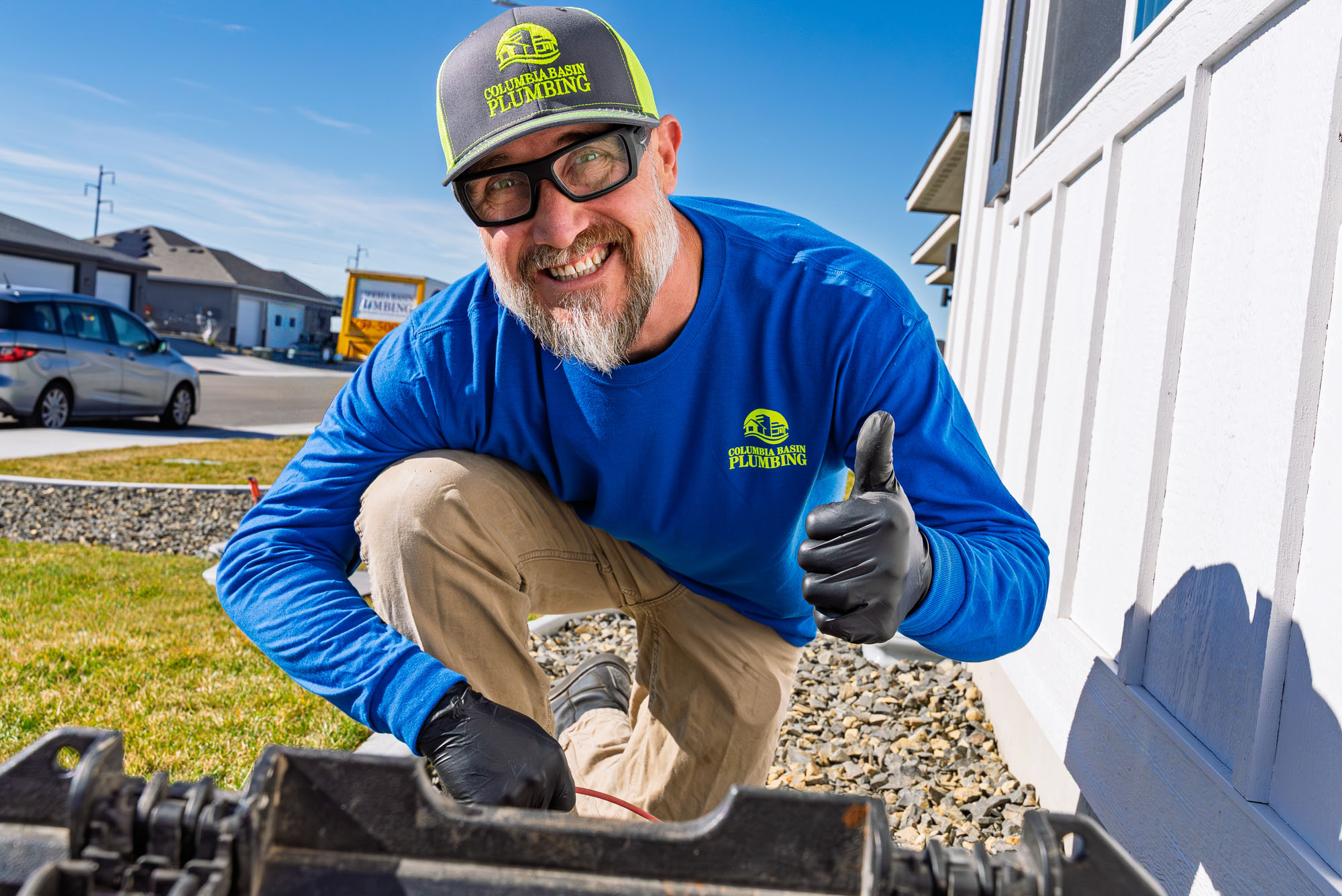 Smiling plumber giving a thumbs up outdoors.