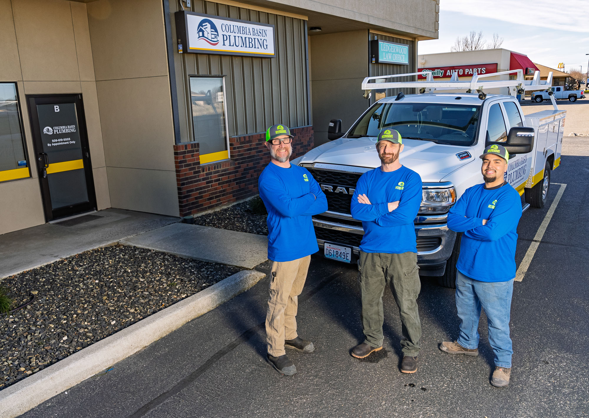 Three plumbers pose beside Columbia Basin Plumbing truck.