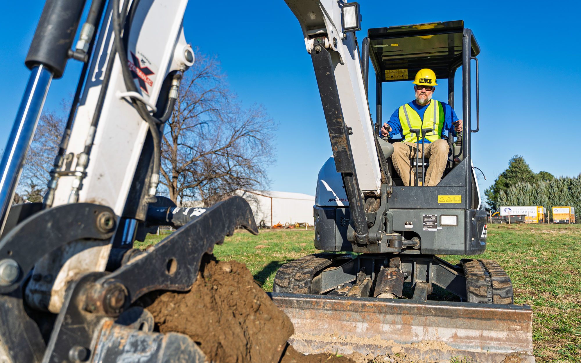 Construction worker operating excavator on job site.