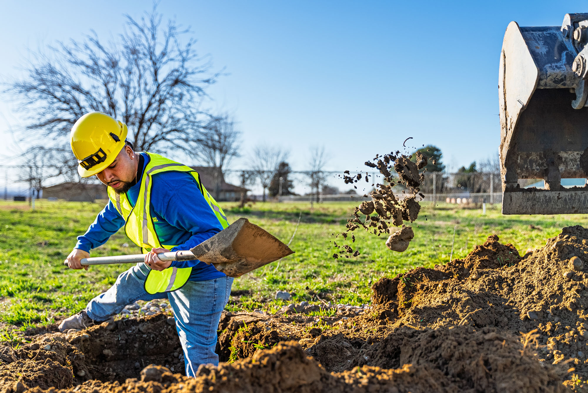 Construction worker digging with shovel at site