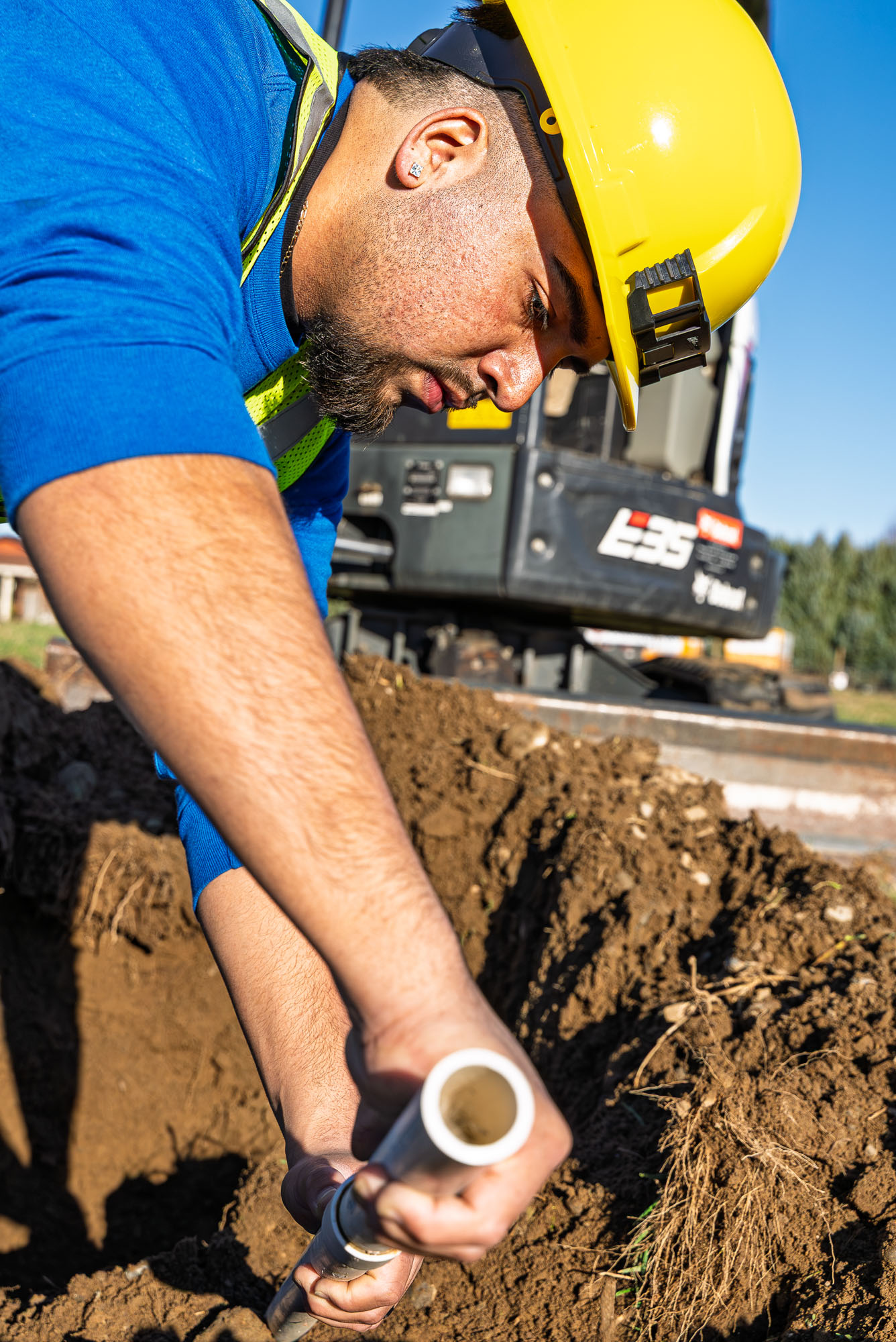 Construction worker installing underground pipe.